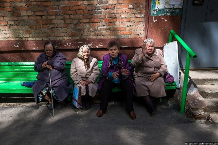 На скамейке во дворе бабушки сидят